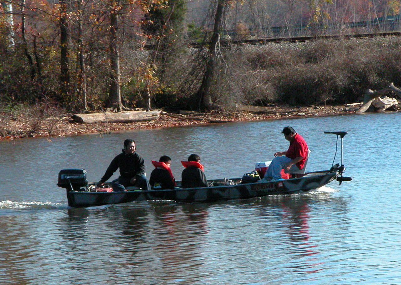 Bass boat rigged for fish finder testing on a sunny lake morning.